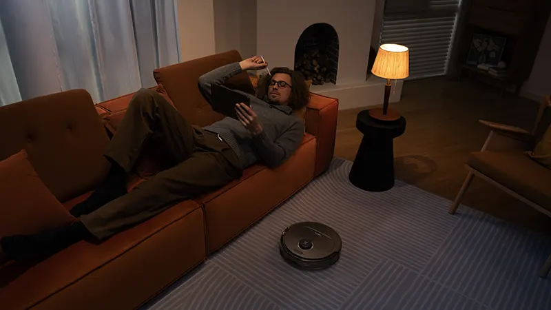 roborock qrevo pro recensione ragazzo sul divano con robot aspirapolvere nero